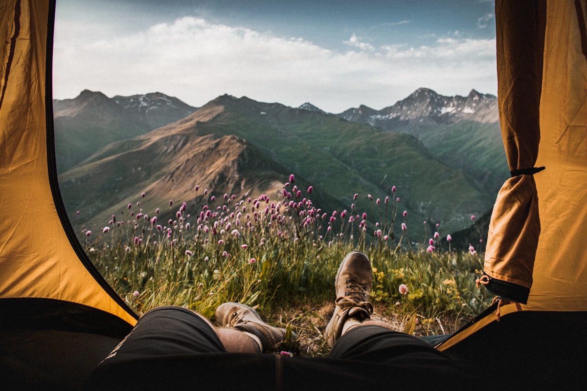 A person lying inside a tent looking out at mountains - solo camping sleep system guide
