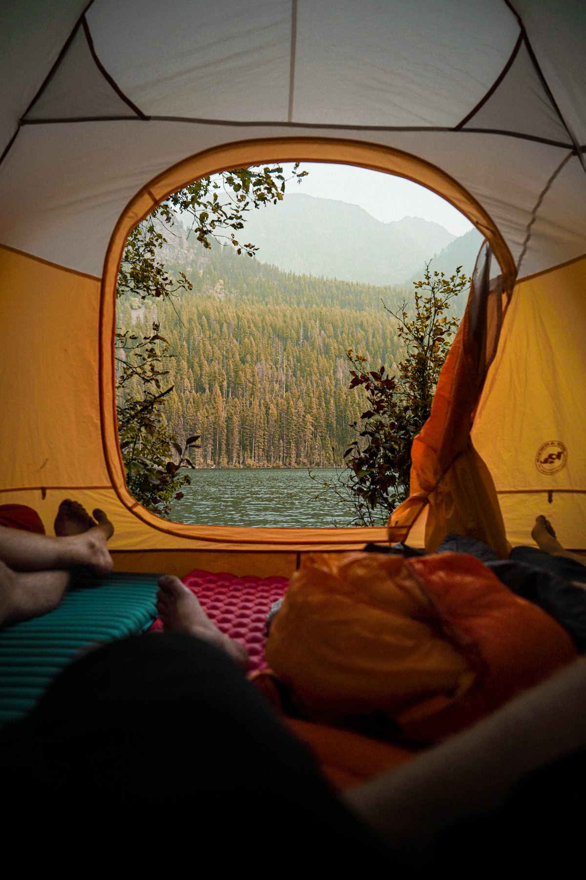 A tent pitched beside clear water at a lakeside camp - solo camping water purification